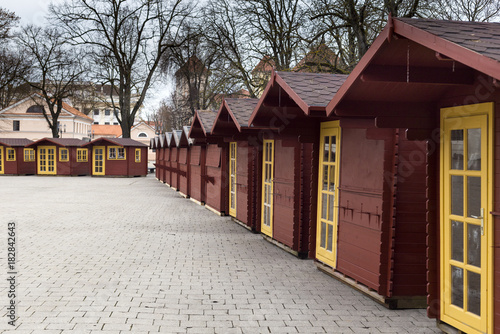 Christmas fair cabins perspective view. A raw of small colored houses on sett square