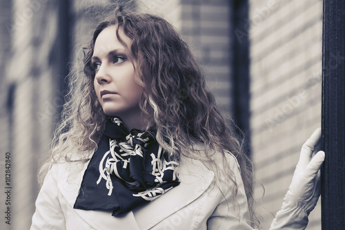 Beautiful fashion woman in white trench coat walking in city street © Wrangler