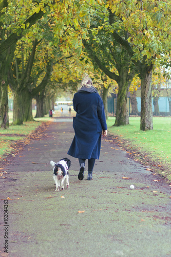woman and dog walking and playing in the park
