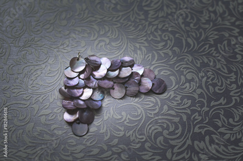 Women's jewelry earrings of metal round plates, on a patterned background