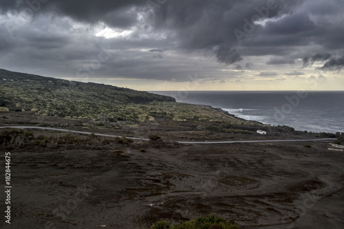 a road leading to a white house on the deserted coast of the volcanic faial island of the Azores