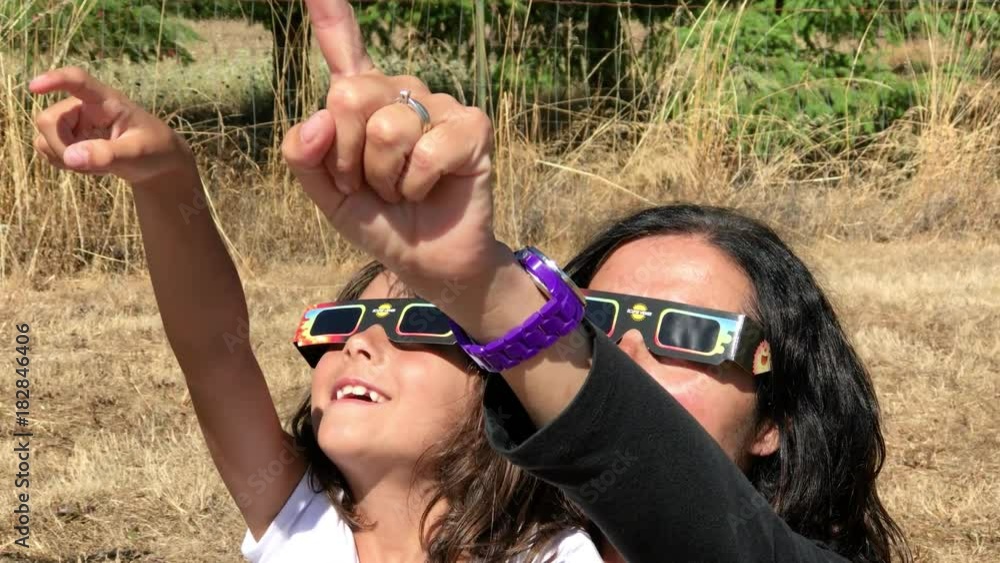 Mother and daughter excited watching solar eclipse together