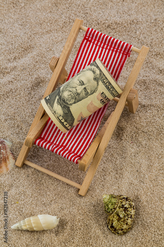 deck chair with piggy bank and dollars