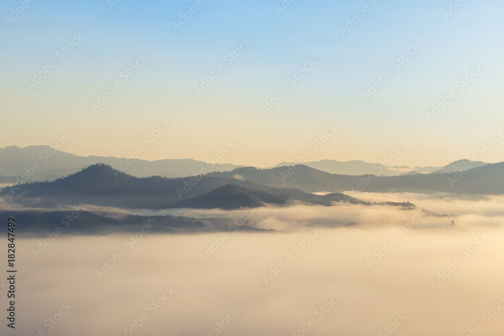   High angle view over tropical rainforest mountains with white fog in early morning in Thailand.