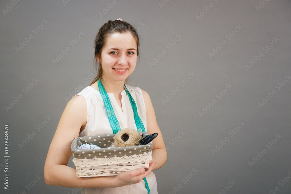 pretty seamstress with tape measure and holding basket with tailor equipments pretty seamstress with tape measure and holding basket with tailor equipments