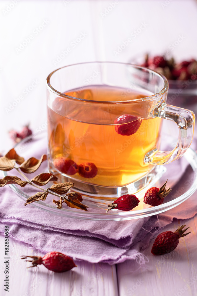 Cup of herbal tea from rose hips on purple wooden background Cup of herbal tea from rose hips on purple wooden background