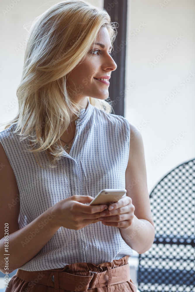 Portrait of pretty blonde woman holding cell phone. Portrait of pretty blonde woman holding cell phone.