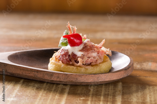blinis of puba dough, smoked meat, coriander and minced pepper