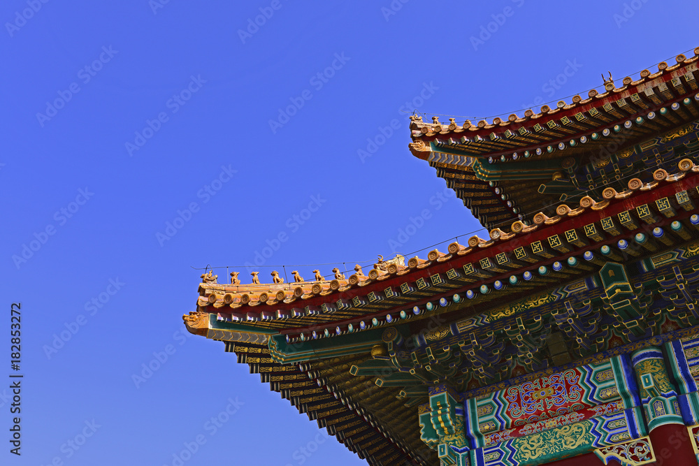A corner of an ancient building under a blue sky A corner of an ancient building under a blue sky