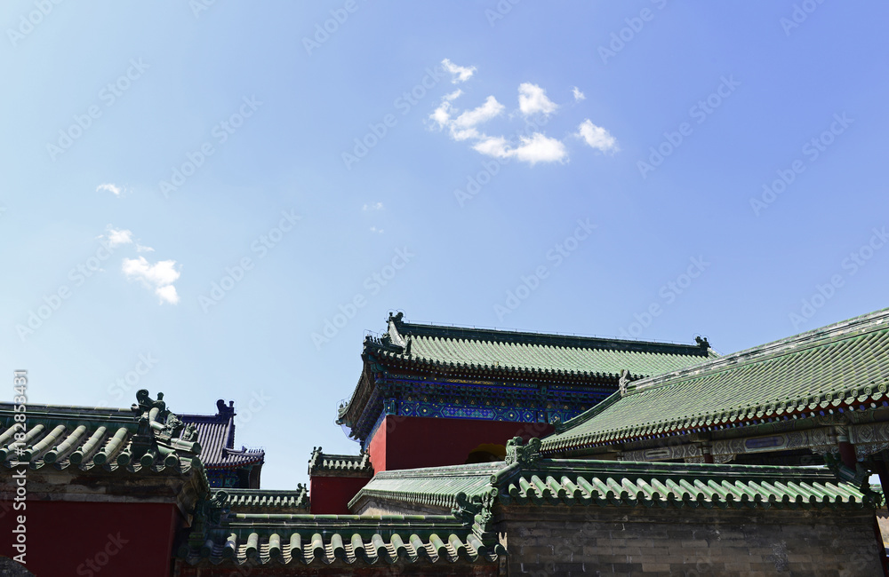 A corner of an ancient building under a blue sky A corner of an ancient building under a blue sky