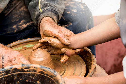 Potter's hands creating a clay vase on a circle. Handmade.