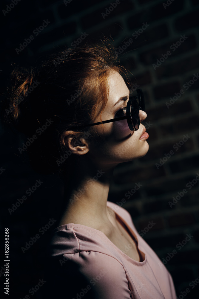 Beautiful young woman in sunglasses on the street, darkness Beautiful young woman in sunglasses on the street, darkness