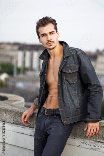 Sexy young man in denim jeans posing outdoors © sakkmesterke