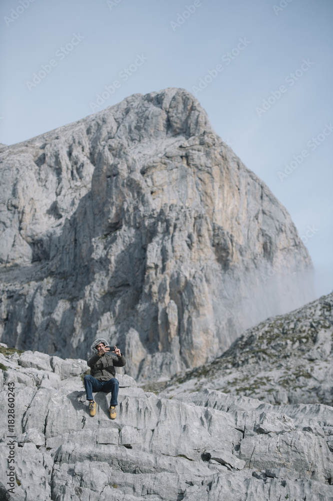 young man with smartphone in the mountain
