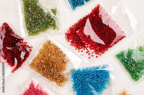 Obraz na plátně Different colour beads for handcraft and beading in plastic packages on a white