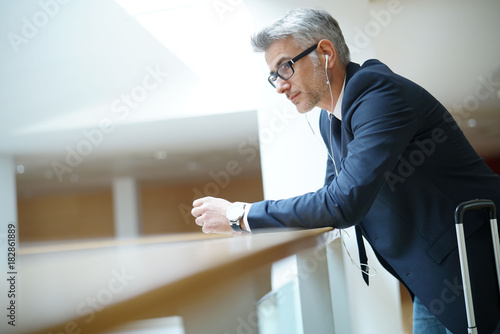Businessman with suitcase at airport departure hall