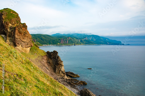 積丹半島、神威岬の夕暮れ前の夏風景、リアス式海岸、緑の低木と厳しい崖