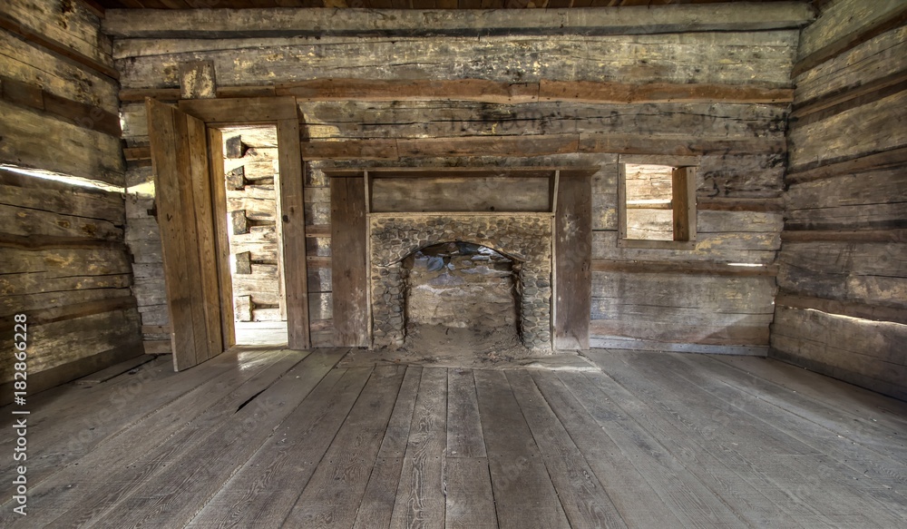 Pioneer Log Cabin Interior. Wooden interior of historic pioneer cabin living room with hardwood floor and fireplace.