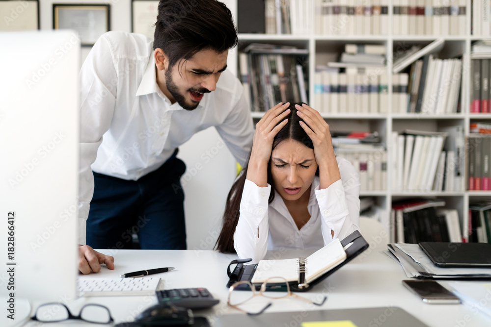 Angry boss yelling at his employee in office Angry boss yelling at his employee in office