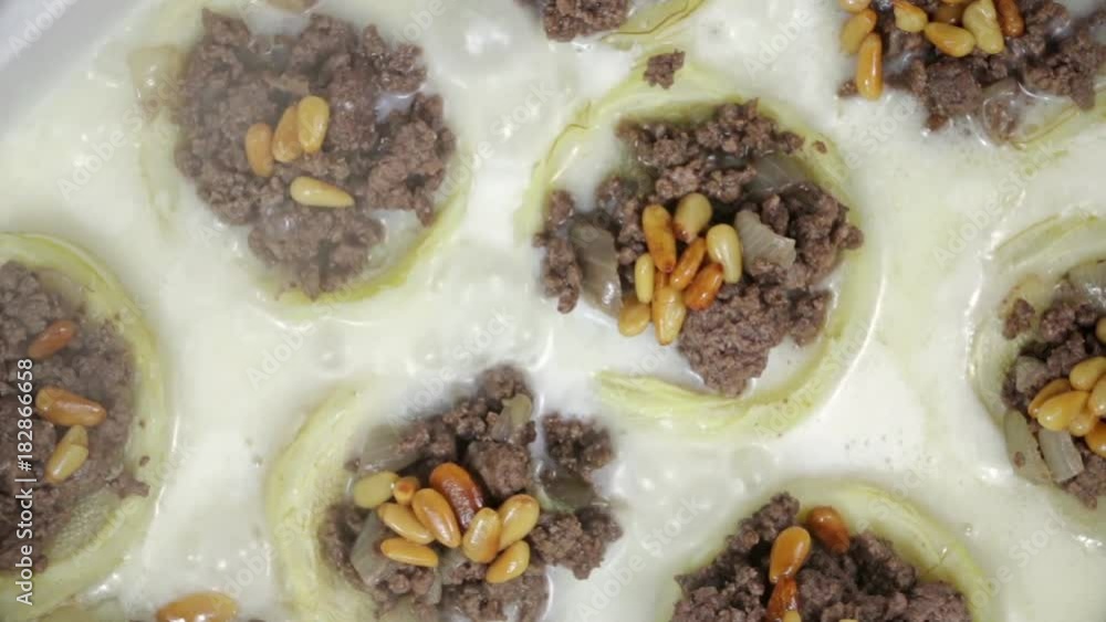 Close-up of White sauce simmering in a casserole of cooked artichokes filled with ground beef and pine. Close-up of White sauce simmering in a casserole of cooked artichokes filled with ground beef and pine.
