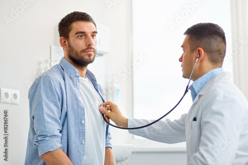 doctor with stethoscope and patient at hospital photo