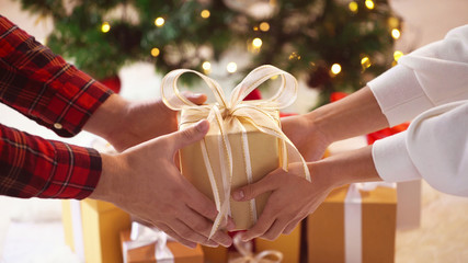 close up of couple hands with christmas gift box