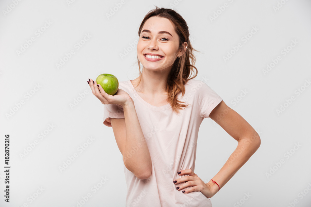 Portrait of a smiling pretty girl holding an apple Portrait of a smiling pretty girl holding an apple