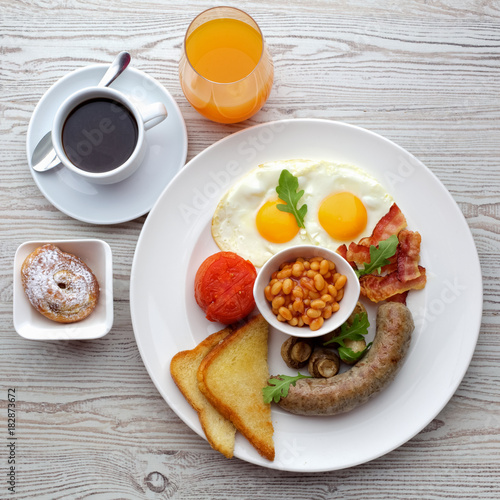 Traditional Full English Breakfast - sunny-side-up fried eggs, sausages, beans, mushrooms and bacon