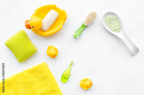 Baby bath set with yellow rubber duck. Soap  sponge  brushes  towel on white background top view copyspace