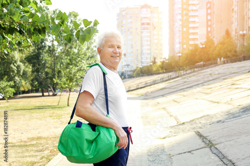 Mature man with bag, outdoors
