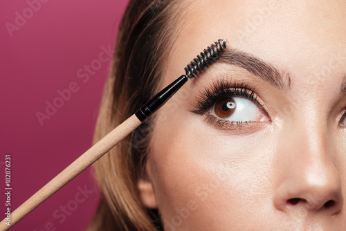 Photo Cropped photo of young lady paint eyebrow with brush isolated