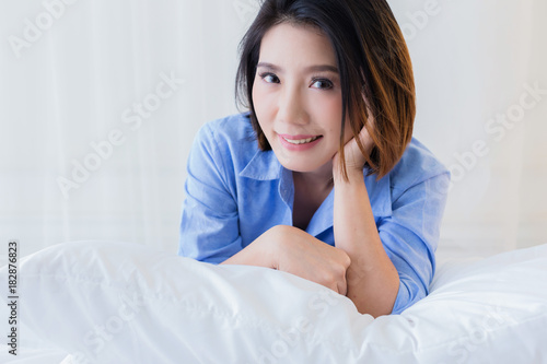 beautiful asian girl casual costume ralax on white bed next to window curtian with sunlight beauty skin concept
