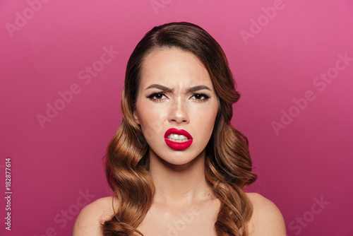 Displeased lady grimacing isolated over pink