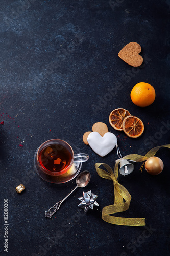 Teatime with heart-shaped ginger cookies and tangerines. Christmas background with festive decoration. Vertical composition