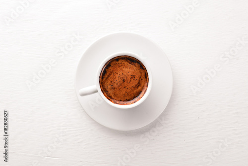 Espresso coffee cup on a white wooden background. Top view. Free space for text.