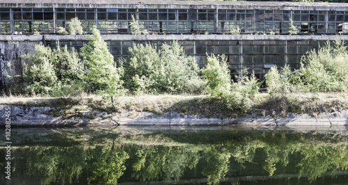 Abandoned industrial hall in Romania  outside view  reflected in a river