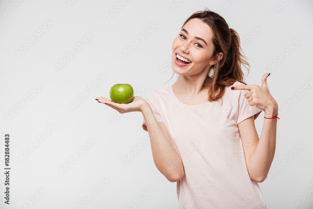 Portrait of a smiling pretty girl holding an apple Portrait of a smiling pretty girl holding an apple