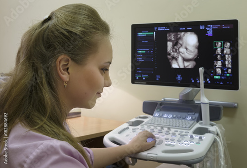 young woman doctor is viewing an ultrasound result to test for visible trisomy 21 signs photo