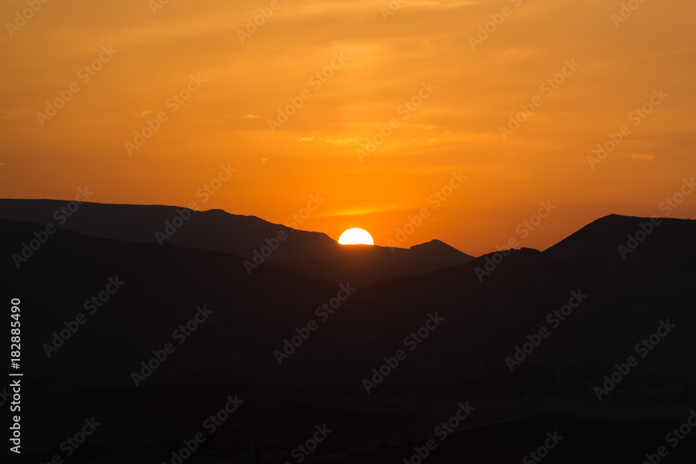 Sunset with the sun in the mountains