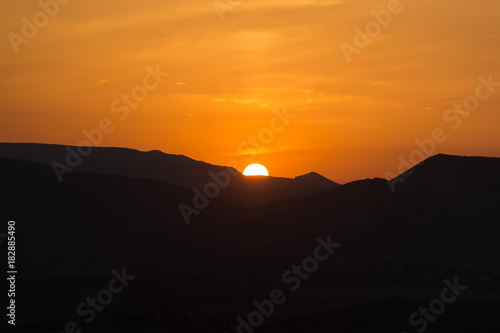 Sunset with the sun in the mountains