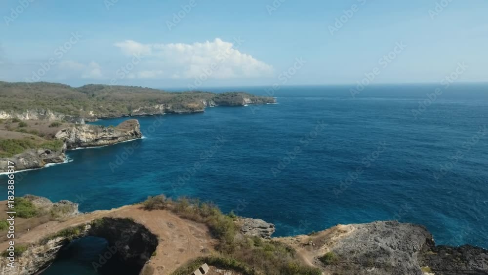 Aerial view of Rocky coast with high cliffs, sea surf with breaking waves on the coast, Nusa Penida, Indonesia. Ocean with waves and rocky cliff. 4K video. Travel concept Aerial footage Aerial view of Rocky coast with high cliffs, sea surf with breaking waves on the coast, Nusa Penida, Indonesia. Ocean with waves and rocky cliff. 4K video. Travel concept Aerial footage