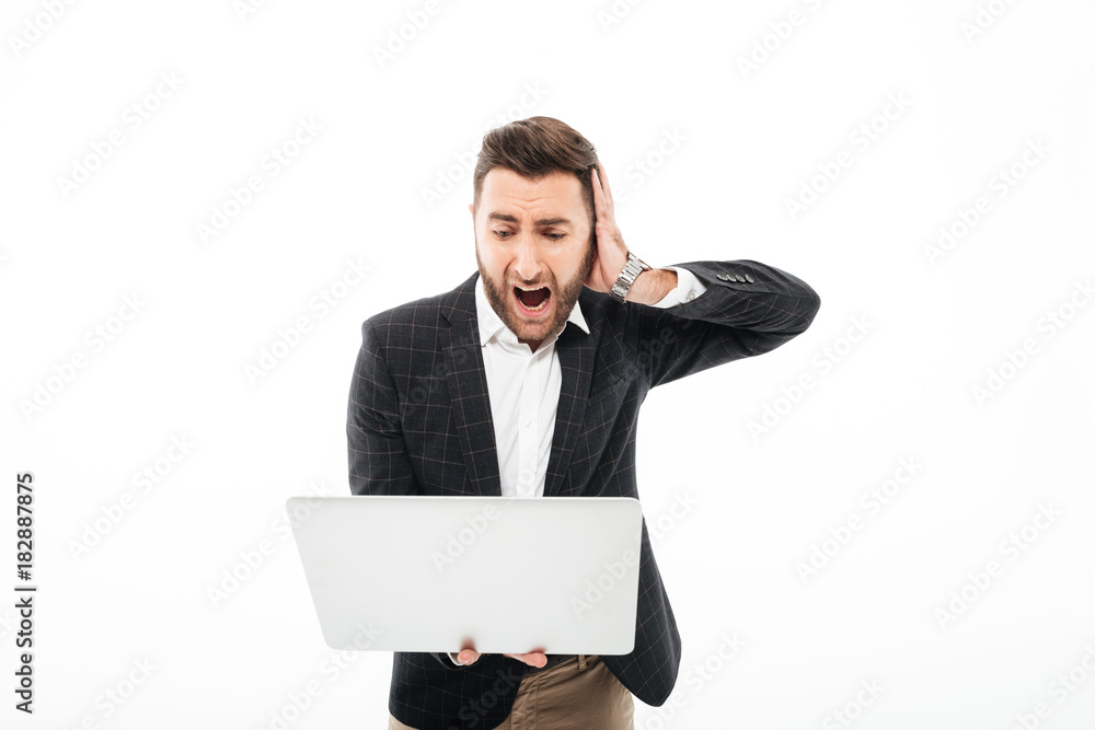 Portrait of an angry bearded man holding laptop computer Portrait of an angry bearded man holding laptop computer