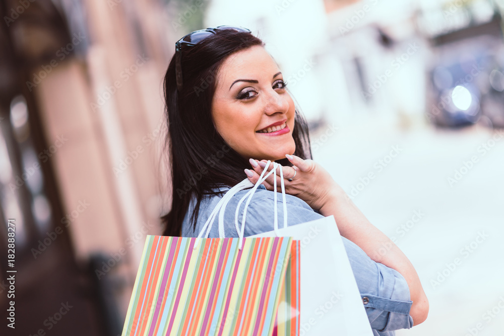Young woman walking with shopping bags in hand