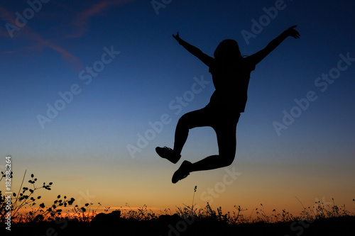 Silhouette of a woman jumping happily