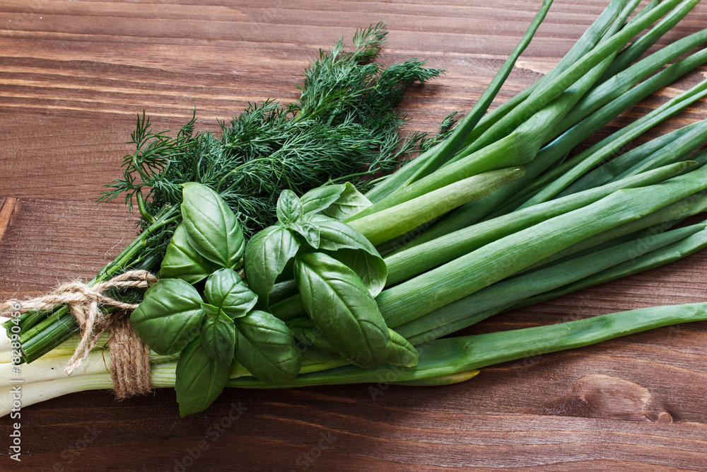 Fresh herbs on the kitchen table. Onions, basil and dill. Selective focus. Top view. Fresh herbs on the kitchen table. Onions, basil and dill. Selective focus. Top view.