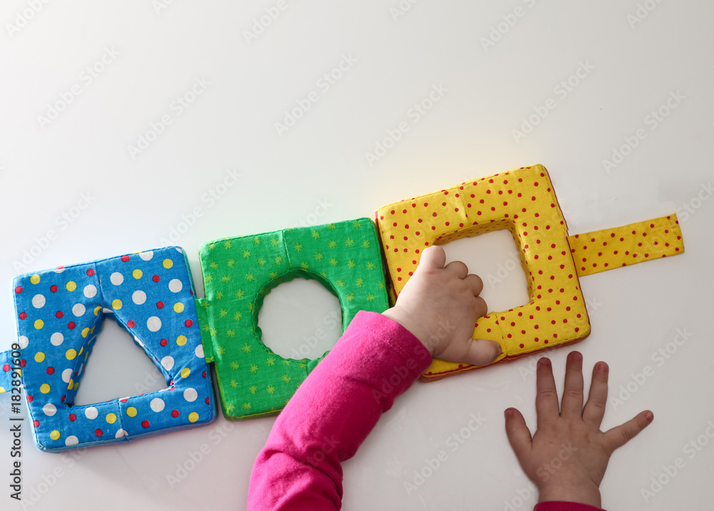 Obraz premium Child's hand, playing with montessori toys. Soft sorter