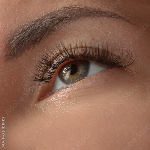 Female beautiful brown eye close-up. Eye pupils close-up