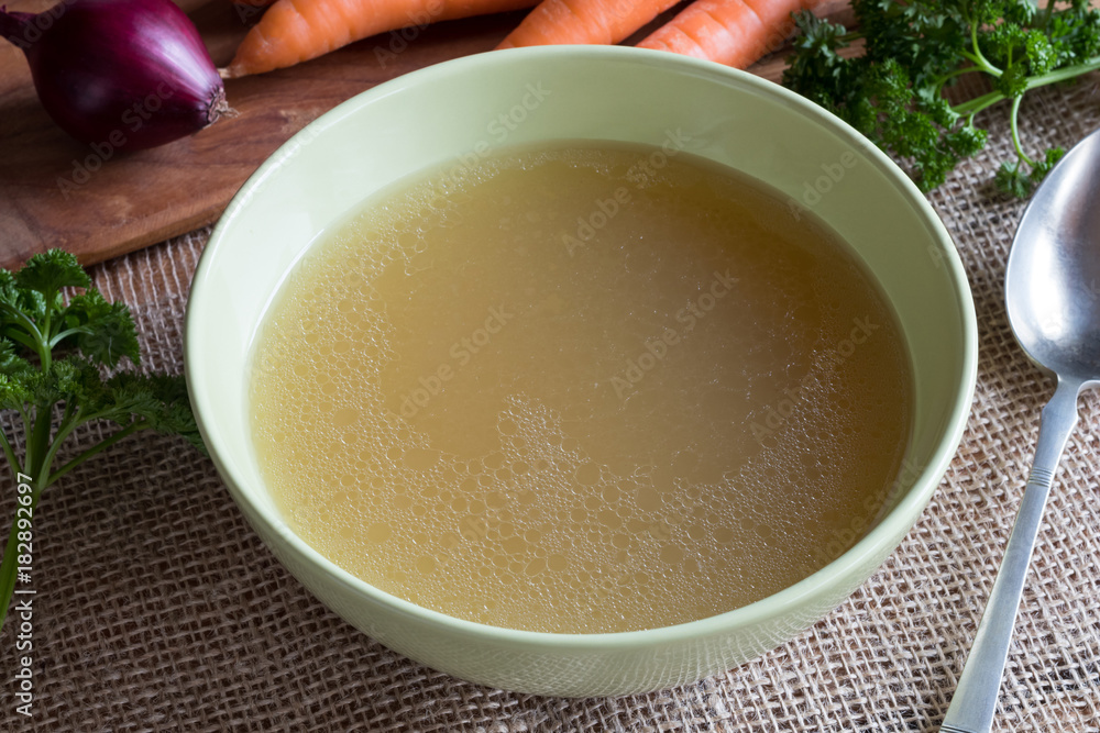 Chicken bone broth in a green soup bowl Chicken bone broth in a green soup bowl