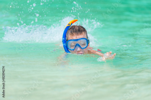 boy in the sea water in the steamy poppy with snorkel tube