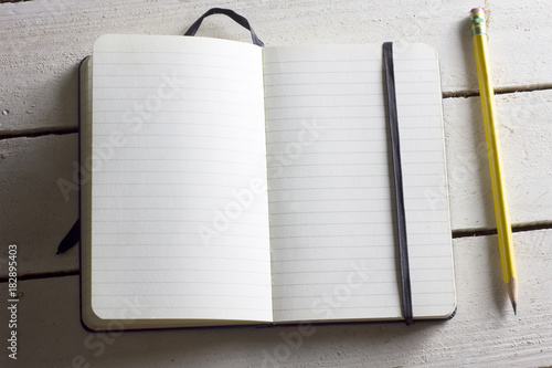 Caderno em branco aberto com lápis apontado amarelo em cima photo